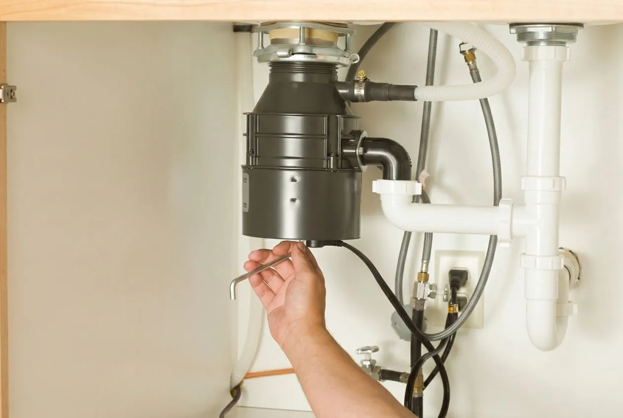 Plumber installing a garbage disposal in San Angelo & Abilene, TX